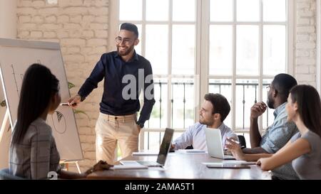 Smiling Arabian male speaker laugh talking with diverse employees Stock Photo