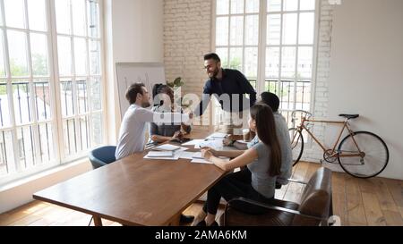 Smiling multiethnic businessmen handshake at office meeting Stock Photo