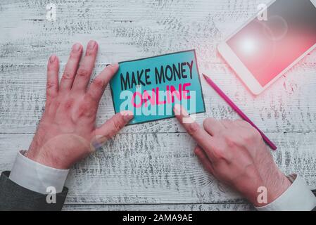 Writing note showing Make Money Online. Business concept for Ecommerce Trading Selling over the internet Freelance Hand hold note paper near writing e Stock Photo