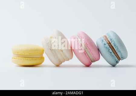 Multicolored macarons arranged in a row with each next cake leaning on the other Stock Photo