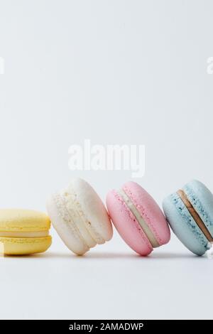 Multicolored macarons arranged in a row with each next cake leaning on the other Stock Photo