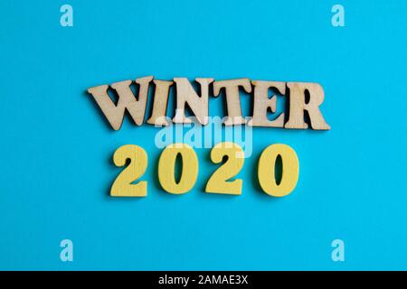 The concept of winter in the new year. Wooden numbers 2020 with letters on a blue background. Top view. Close up. Stock Photo