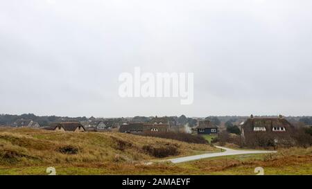 Standing on a dune and looking at a group of traditional holiday homes near Buren on the Wadden sea island Ameland. Stock Photo