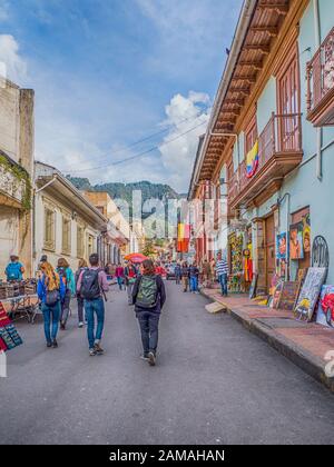 Bogota, Colombia - November 28, 2019: Street of Bogota with colonial colorful houses and mountain view in the background, La Candelaria district. Stock Photo