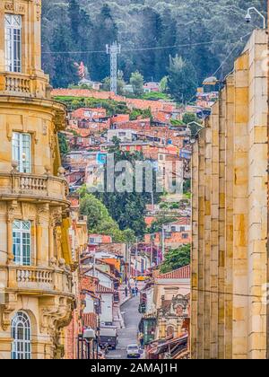 Bogota, Colombia - November 28, 2019: Street of Bogota with colonial colorful houses and mountain view in the background, La Candelaria district. Stock Photo