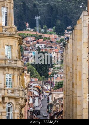 Bogota, Colombia - November 28, 2019: Street of Bogota with colonial colorful houses and mountain view in the background, La Candelaria district. Stock Photo