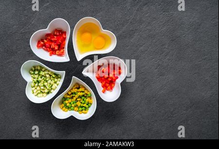 Top view of ingredients for scrambled eggs on black stone background Stock Photo
