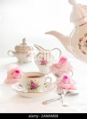 A set of  floral rose pattern fine china porcelain tea set with a tea-pot, sugar pot, creamer, and tea cup. Stock Photo