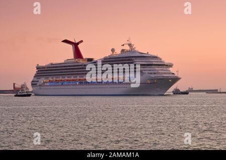 M/S Carnival Triumph cruise ship, operated by Carnival Cruise Lines, Bahamas flag, in Galveston Bay at sunrise, coming to port of Galveston, Texas USA Stock Photo