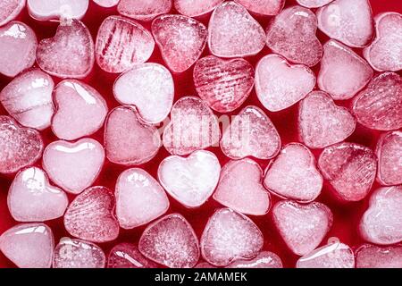 Romantic red background of hearts. Card with heart shaped ice. Texture, pattern. Symbol of valentine's day Stock Photo