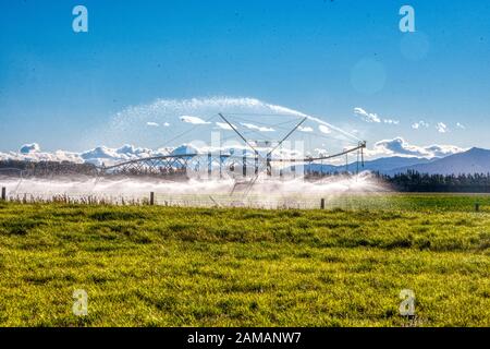 Giant irrigation water sprinklers on pasture land near Ashburton, New Zealand Stock Photo