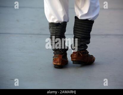 Dancersfeet in a traditional Romanian dance wearing traditional beautiful costumes. Close up of folklore shoes. Stock Photo