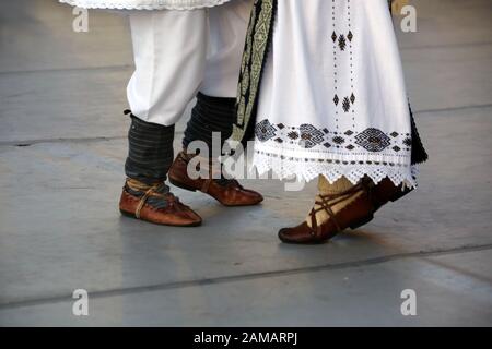 Dancersfeet in a traditional Romanian dance wearing traditional beautiful costumes. Close up of folklore shoes. Stock Photo