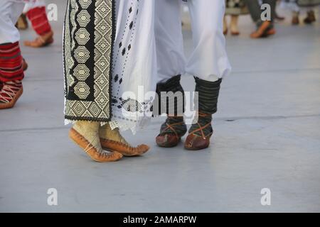 Dancersfeet in a traditional Romanian dance wearing traditional beautiful costumes. Close up of folklore shoes. Stock Photo