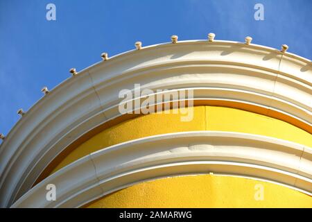 A detail of a bright and sunny yellow building against a clear blue sky Stock Photo