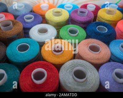 A lot of sewing colored thread. Thread reels. Colorful threads in the box. Texture of sewing accessories Stock Photo