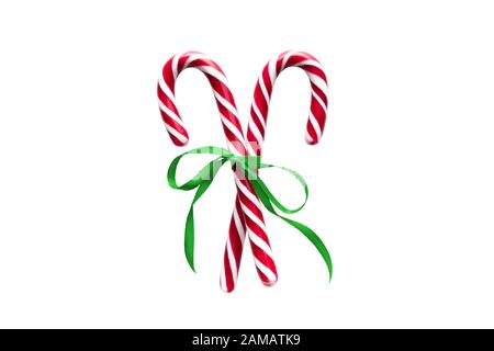 Two red and white Christmas candy canes with green Ribbon bow, isolated on white background Stock Photo