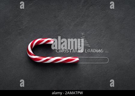 Christmas loading Concept - Candy cane on blackboard with christmas tree Stock Photo