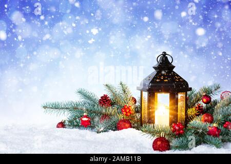 Christmas Lantern On Snow With Fir Branch and Baubles. Winter Decoration Background Stock Photo