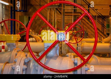 Red painted hand wheels for opening or close the hand valves in the industrial pipes Stock Photo