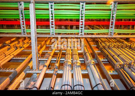 Electrical grey cables mounted in a rack for power supply in a industrial area Stock Photo
