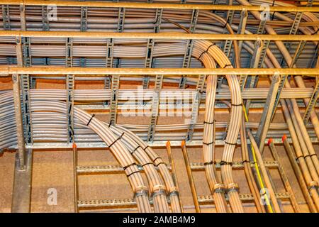 Electrical grey cables mounted in a rack for power supply in a industrial area Stock Photo