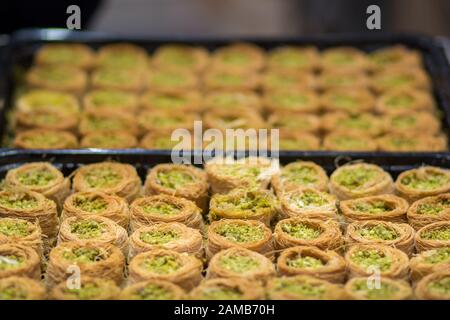 Baklava (modern Middle Eastern Arab-style dessert) baked with sugar and honey syrup, sweet and stuffed with almonds, nuts and pistachios. old city. Stock Photo