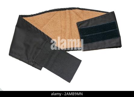 Close up of black medical waist belt for back pain isolated on white background. Top view. Lower back warming belt for pain relief and recovery. Stock Photo