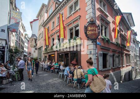 People seated outside a Spanish restaurant have lunch on tables. Zurich old town. Switzerland Stock Photo