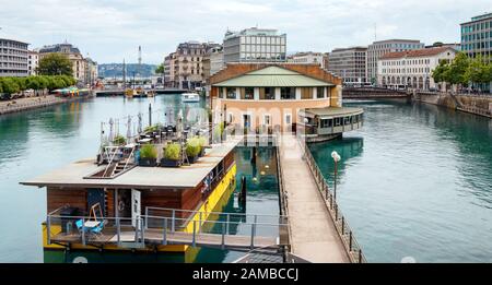 View of the Rhone River with on left the Quai Turrettini, in the centre Place de L'Ile and Quai de la Poste on the right. Geneva, Switzerland. Stock Photo