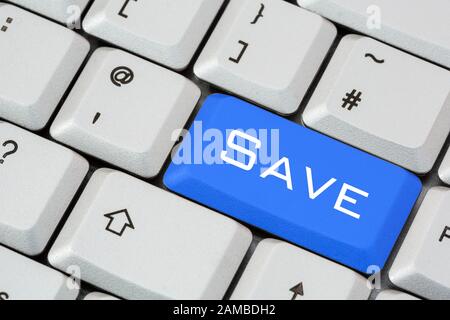 A keyboard with the word Save written in white lettering on a blue enter key. Saving money concept. England, UK, Britain Stock Photo