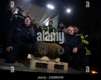 Dortmund, Germany. 12th Jan, 2020. Bomb disposal expert Karl-Friedrich Schröder (l) shows the detonator of one of two defused bombs from the Second World War on the loading area of a truck with his team. No unexploded ordnance had been detected at two other suspected sites. The aircraft bombs were located in a densely populated residential area. As a result, some 14 000 people had to leave their homes. Credit: Bernd Thissen/dpa/Alamy Live News Stock Photo
