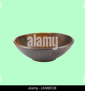 Ceramic bowl on green background with path. View from side Stock Photo