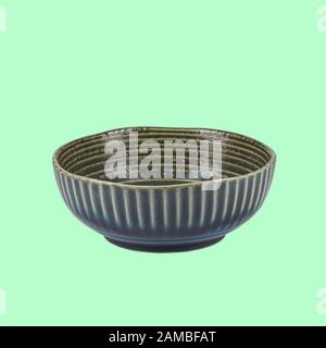 Ceramic bowl on green background with path. View from side Stock Photo