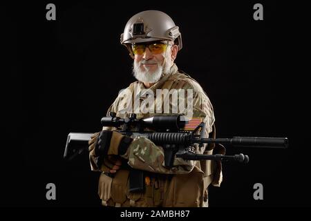 Front view of old smiling military officer holding sniper rifle and ...