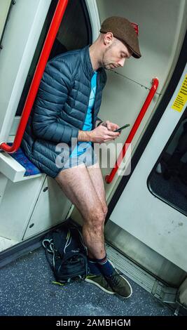 London, UK. 12th Jan, 2020. Members of the public take part in the No Trousers Tube Ride 2020 which involves riding on an underground train with no trousers or skirt on and behaving normally, reading a book or listening to music. Credit: ernesto rogata/Alamy Live News Stock Photo
