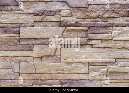 Texture of beige facade stone for exterior decoration of the house. Stock Photo