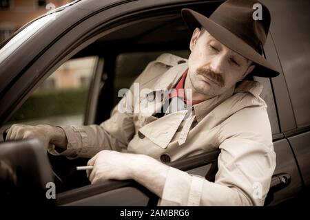 Detective smoking a cigarette in his car while stalking Stock Photo