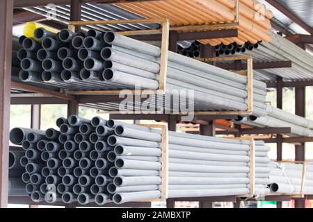 gray PVC tubes plastic pipes stacked in rows pattern Stock Photo