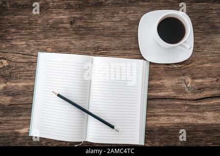 Pencil and an open notebook on wooden table. Bird eye view, mock-up concept Stock Photo