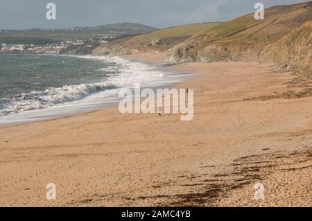 Distant figure on beach at Gunwalloe Cove, Lizard Peninsula, Cornwall, UK Stock Photo