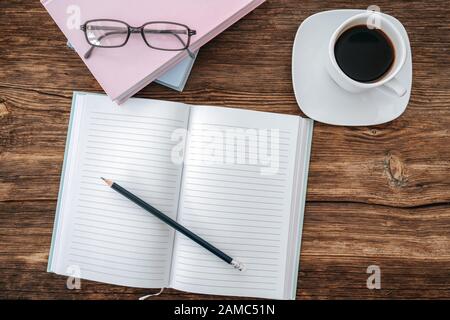 Pencil and an open notebook on wooden table. Bird eye view, mock-up concept Stock Photo