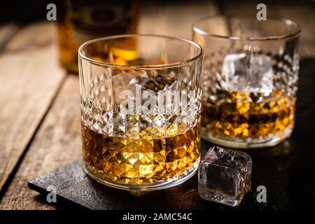 Whiskey in glasses on wood background Stock Photo