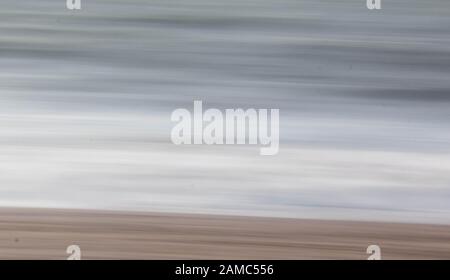 Sea, sand and surf blurred with long exposure and camera motion Stock Photo