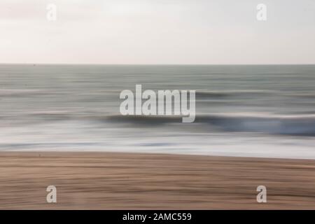 Sea, sand and surf blurred with long exposure and camera motion Stock Photo