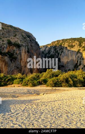 Gjipe beach in Albania at sunset, in the background the mouth of the Gjipe canyon. One of the most interesting places on the Ionian Sea coast. Stock Photo