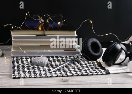Stack of books and notepads on which are glasses and on the side of headphones. nice background. top views Stock Photo