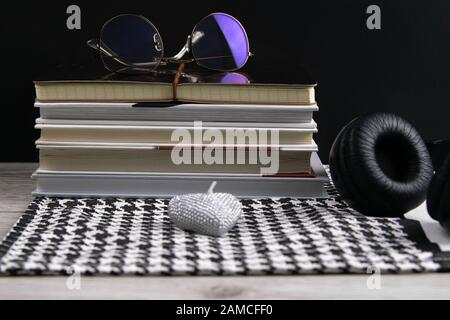 Stack of books and notepads on which are glasses and on the side of headphones. nice background. top views Stock Photo