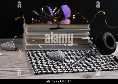 Stack of books and notepads on which are glasses and on the side of headphones. nice background. top views Stock Photo