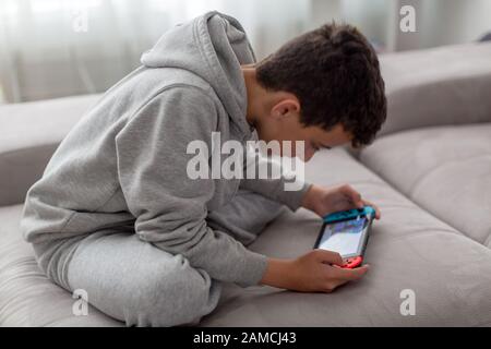 video game console for home or portable gaming. Teenager man playing game on console. Stock Photo